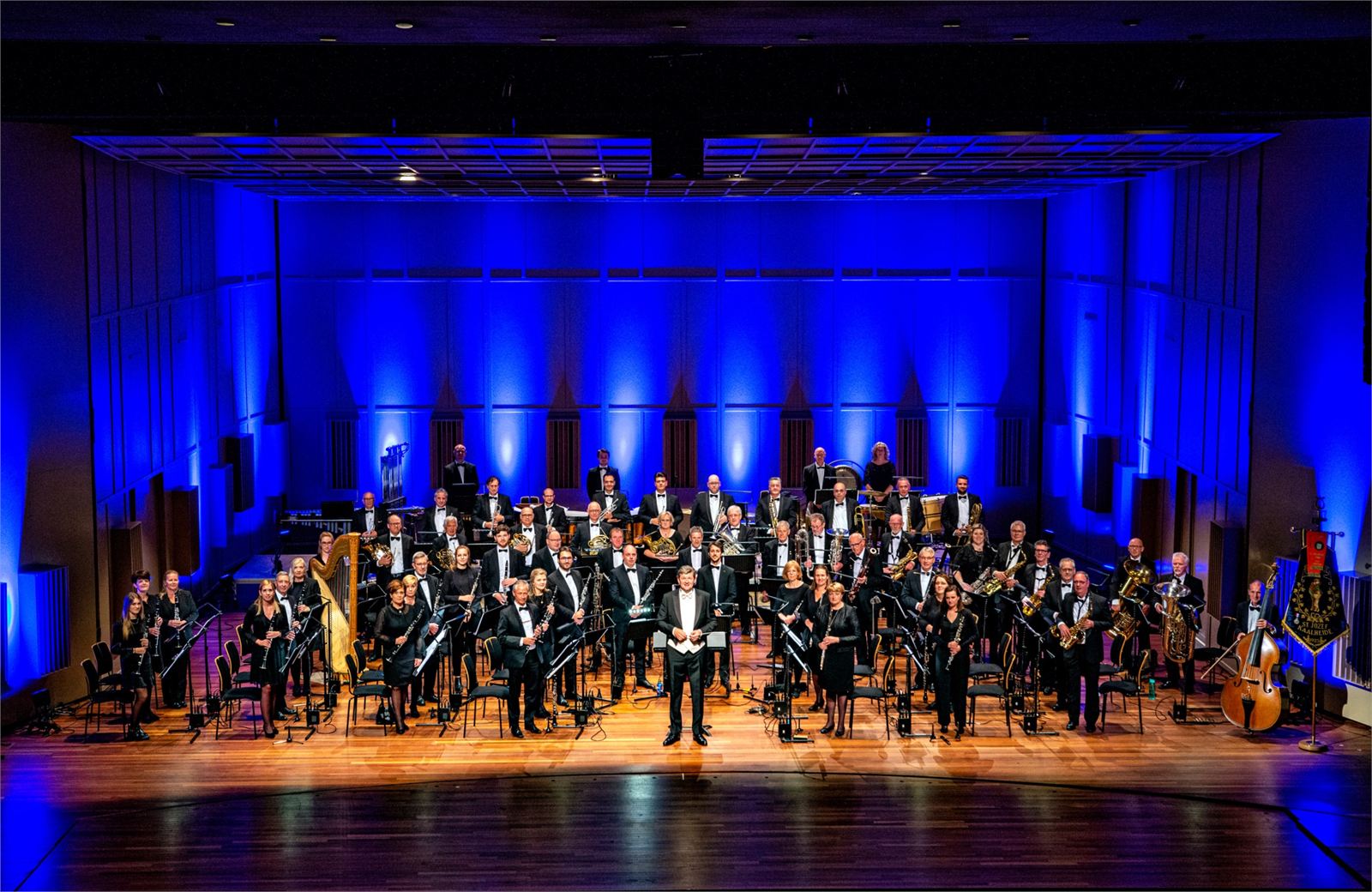 Het orkest in blauw licht op het podium, onder leiding van Georges Moreau