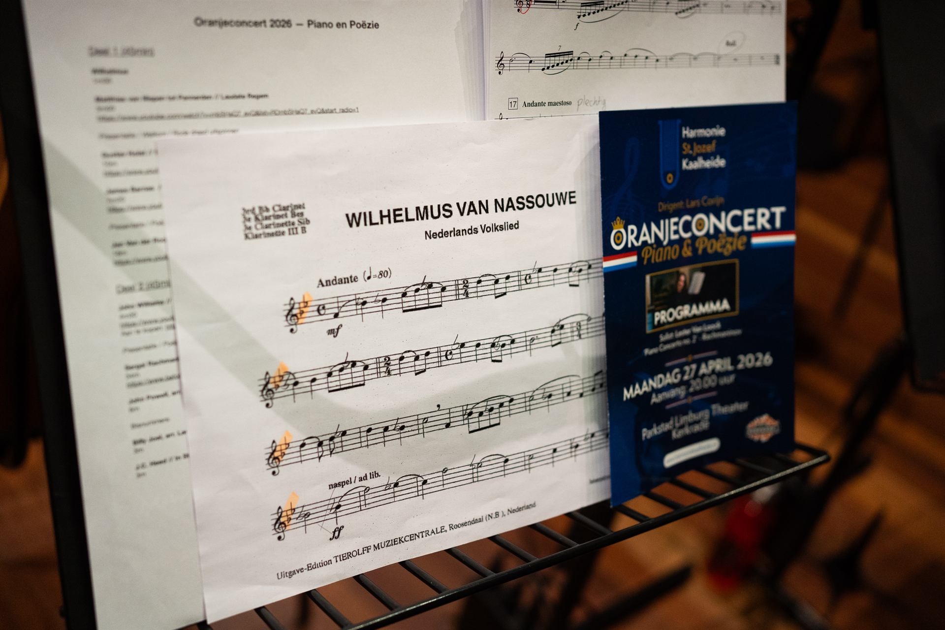 Het programmaboekje en de partituur van het Wilhelmus op een lessenaar