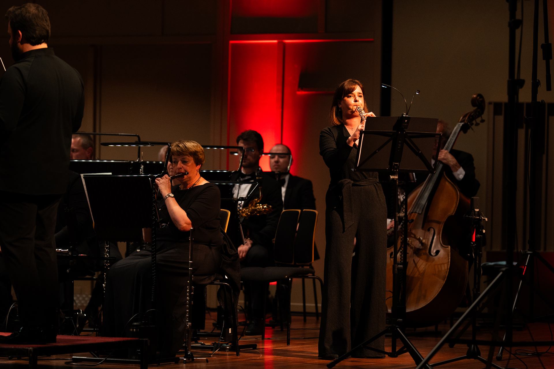 Een soliste aan de microfoon voor het orkest, in rood licht